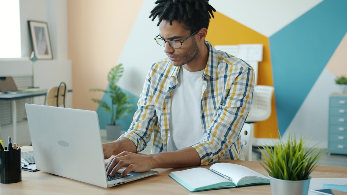 Freelancer working at laptop with contract documents
